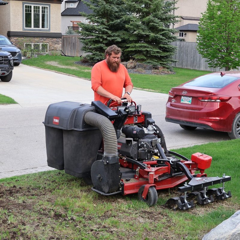A GoYardly crew member operating a Toro stand-on at a Selkirk-area property
